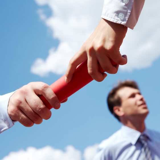 Photo of business people hands passing baton during race